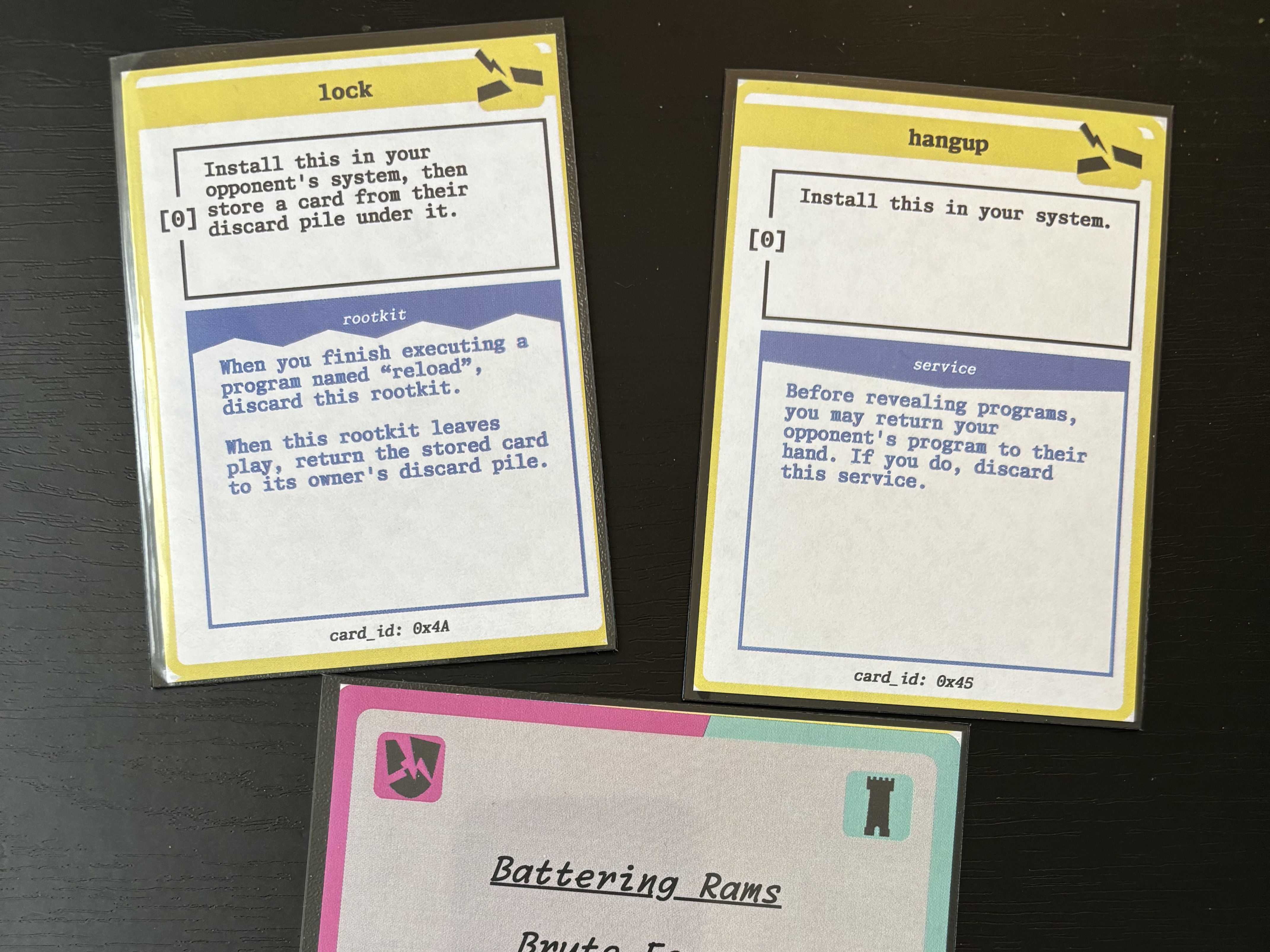 Three prototype CTF cards: two program cards oriented vertically above one team card oriented horizontally